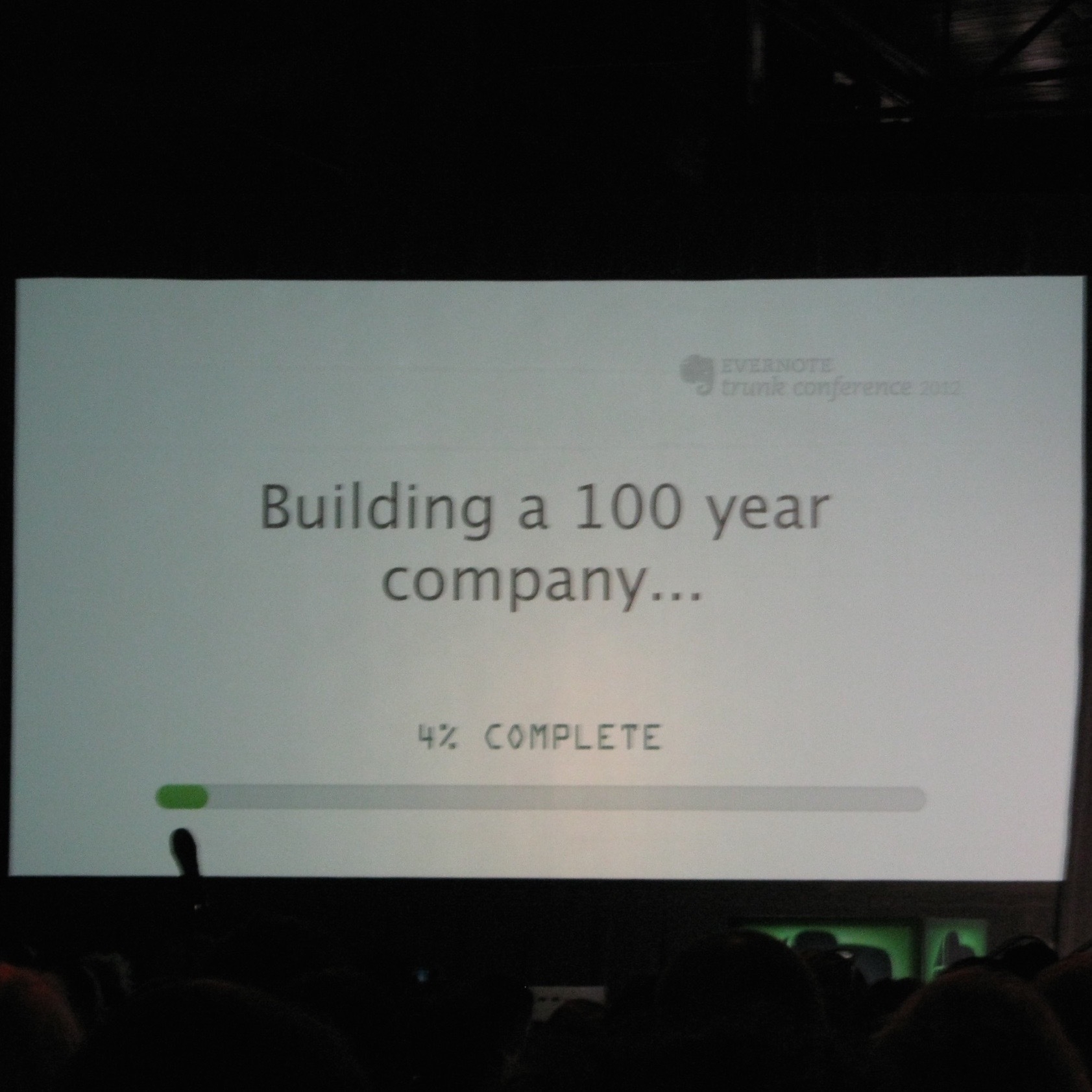 A presentation slide shows the text Building a 100 year company... with a progress bar at 4% complete.