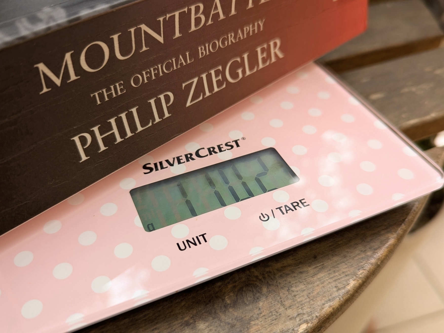 A biography of Mountbatten by Philip Ziegler is resting on a pink polka dot digital scale displaying a weight of 1.102 grams.